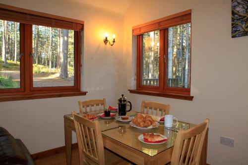 a dining room table with a plate of food on it at Cairngorm Lodges in Aboyne