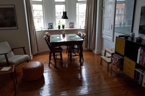 uma sala de estar com uma mesa de jantar e cadeiras em Dejlig lejlighed først for på Amager em Copenhague