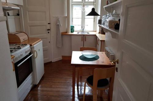 uma cozinha com uma pequena mesa com uma tigela em Dejlig lejlighed først for på Amager em Copenhague