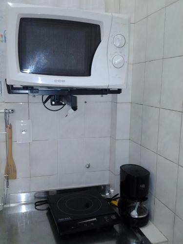 a microwave sitting on top of a stove in a kitchen at Studio Copacabana Ipanema in Rio de Janeiro