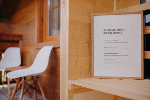 a sign on a wall with two white chairs at VOM REITER, Ferienwohnung am Bauernhof mit Bergblick und privater Infrarotkabine, Inklusive Sommercard in Schladming