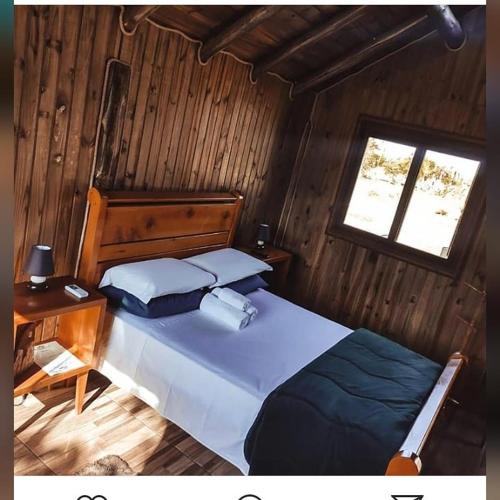 a bedroom with a large bed and a window at Chalés Alvorada in Praia Grande