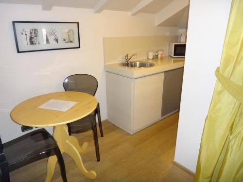 a small kitchen with a table and a sink at Hotel Ariston & Apartments in Varazze