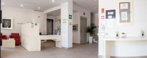 a white room with a desk and a table at Hotel Senderos in Agua Amarga