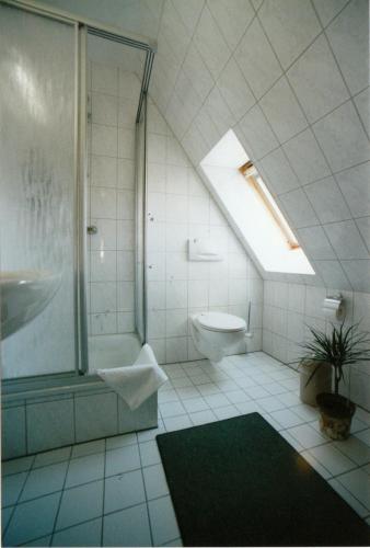 a bathroom with a shower and a toilet and a window at Pension Schwark in Bad Doberan