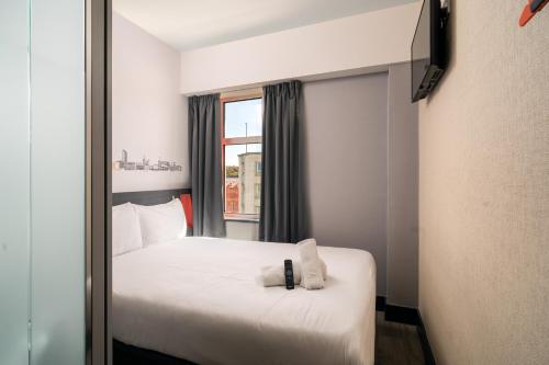 a hotel room with a bed and a window at easyHotel Sheffield in Sheffield