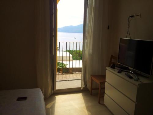 Cette chambre dispose d'une télévision et d'une porte donnant sur un balcon. dans l'établissement Appartamenti del Comandante, à Santa Marina Salina