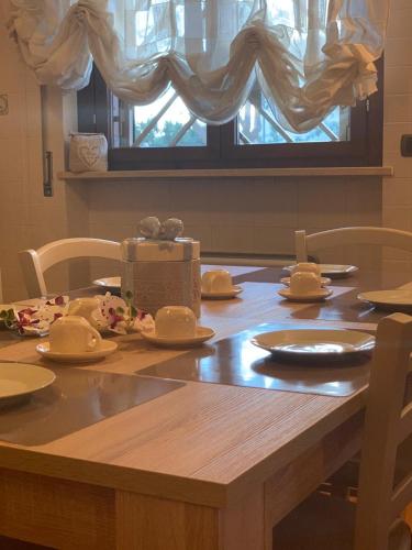 a wooden table with dishes and a box on it at Vacanze in Puglia in Pezze di Greco