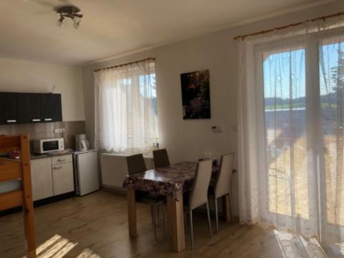 a kitchen and dining room with a table and chairs at Apartmány Eva Frymburk in Frymburk