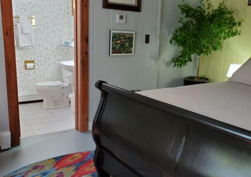 a bathroom with a bed and a bathroom with a toilet at Rugosa Guest House in Eastham