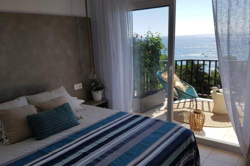 1 dormitorio con 1 cama y balcón con vistas. en Ático de diseño sobre la Cala de las Sirenas!!, en Miami Platja