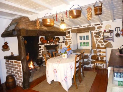 a dining room with a table and a fireplace at Casa do Tamanqueiro in Estorãos