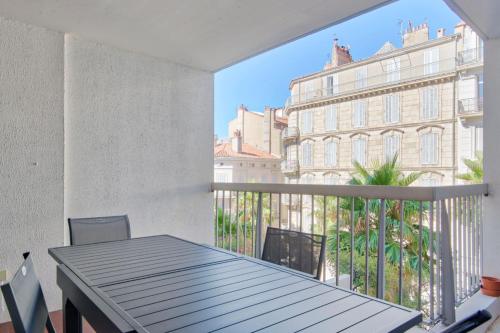 d'un balcon avec une table et une vue sur un bâtiment. dans l'établissement Appartement Gimelli Welkeys, à Toulon