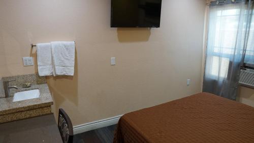 a hotel room with a bed and a sink at Holly Crest Hotel - Los Angeles, LAX Airport in Inglewood