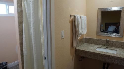 a bathroom with a shower and a sink and a mirror at Holly Crest Hotel - Los Angeles, LAX Airport in Inglewood