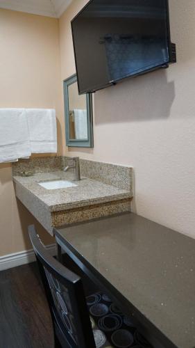 a bathroom with a sink and a mirror at Holly Crest Hotel - Los Angeles, LAX Airport in Inglewood