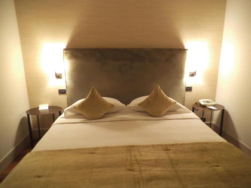 a bedroom with a large white bed with two pillows at Hotel Ariston & Apartments in Varazze