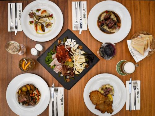 a wooden table with plates of food on it at Absolutum Wellness Hotel in Prague