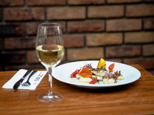 a plate of food and a glass of wine on a table at Absolutum Wellness Hotel in Prague