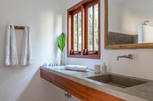 a bathroom with a sink and a mirror at Casa Pini - Condomínio Altos de Trancoso, próxima ao Quadrado in Trancoso