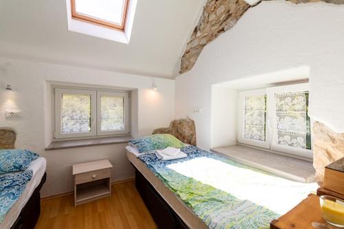 two beds in a room with two windows at Holiday country house Gora in Gozd