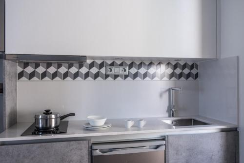 a kitchen with a sink and a pot on a stove at Skajado Holiday Apartments in Stalida