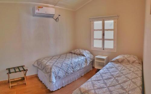 1 dormitorio con 2 camas y ventana en Las Moras Cabañas Boutique en Puerto Iguazú