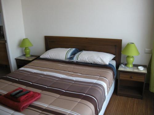 a bedroom with a bed with two lamps on two tables at Zenteno Apartments in Santiago