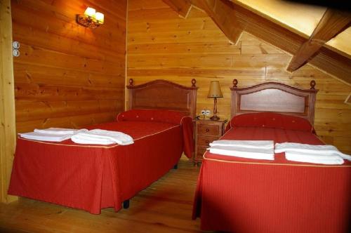 2 Betten in einem Zimmer mit Holzwänden in der Unterkunft CASA DE MADERA ZUMACAR V in Cazorla