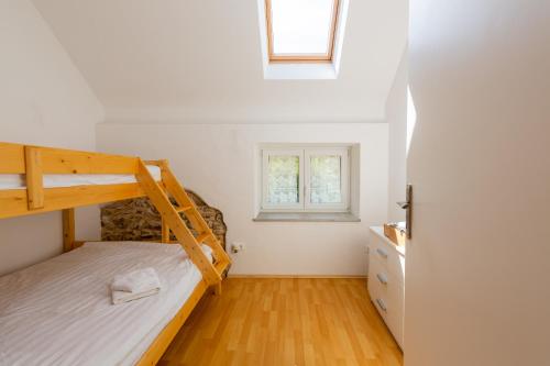 a bedroom with a bunk bed and a window at Holiday country house Gora in Gozd