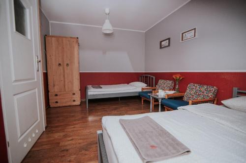 1 dormitorio con 2 camas, mesa y sillas en Agroturystyka Małgosia en Lubiąż