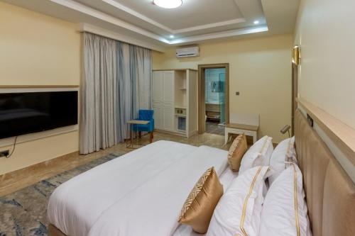 a hotel room with a bed and a television at Hera in Wuse