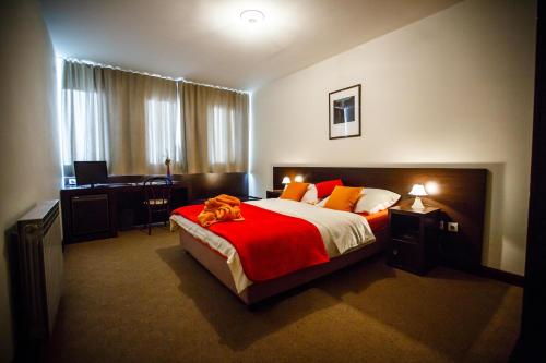 sypialnia z dużym łóżkiem i czerwonym kocem w obiekcie Hotel Sv. Mihovil w mieście Trilj