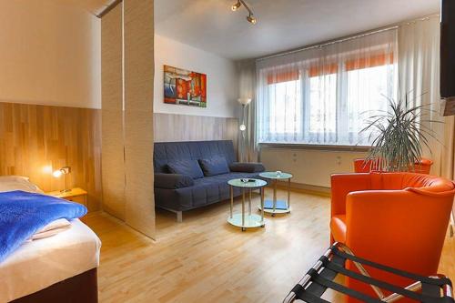 ein Schlafzimmer mit einem Bett, einem Sofa und einem Tisch in der Unterkunft H&H Apartment im Herzen der Stadt Nr 29-Henning mit Balkon in Greifswald