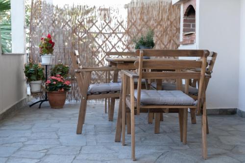 a wooden table and chairs on a patio at Melanthi Apartment in Keramotí