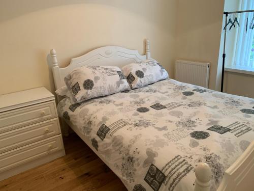 a bed with a comforter and pillows in a bedroom at 105 Nelson Street in Largs