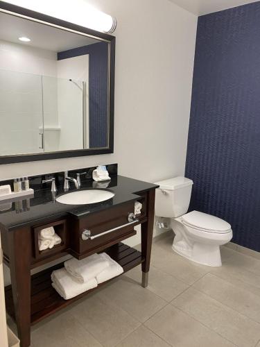 a bathroom with a sink and a toilet and a mirror at Cherokee Grand Hotel in Cherokee