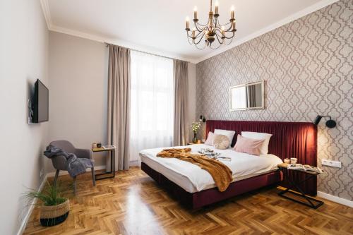 ein Schlafzimmer mit einem großen Bett und einem Kronleuchter in der Unterkunft Papillon Apartment by LoftAffair in Krakau
