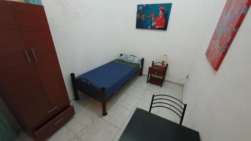 Hostelmo Hotel في بوينس آيرس: غرفة نوم صغيرة مع سرير صغير وطاولة