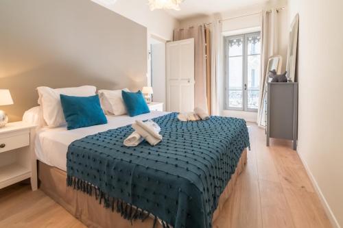 - une chambre avec un lit avec des draps bleus et 2 serviettes dans l'établissement Appartement Fiora - Welkeys, à Avignon