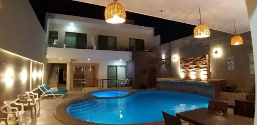a large blue swimming pool in a room with chairs at Hotel & Suites Domani in Progreso