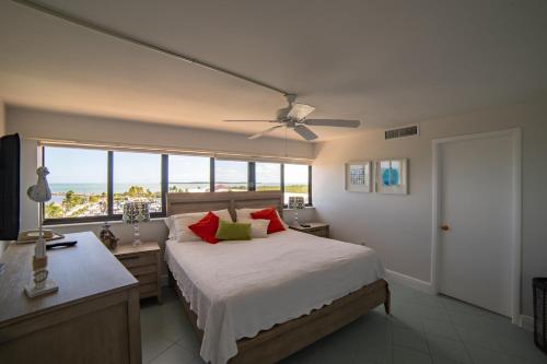 Schlafzimmer mit einem Bett mit roten Kissen und einem Fenster in der Unterkunft Kawama Yacht Club Apartment in Key Largo