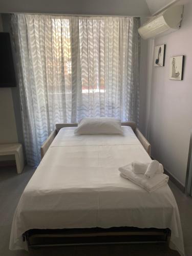 a bedroom with a bed with white sheets and a window at Donna Teresa in Naples