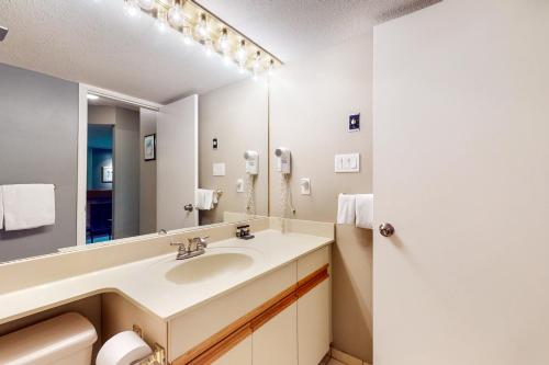 een badkamer met een wastafel en een grote spiegel bij The Gables 39 in Whistler