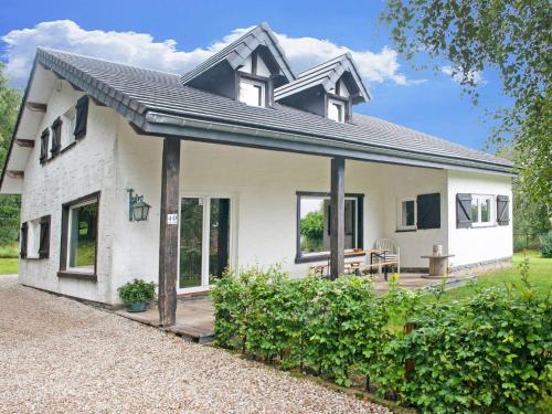 een klein wit huis met een veranda en een patio bij Holiday Home in Xhoffraix between Spa and Eifel Nature Park in Xhoffraix