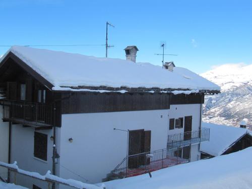 a white building with snow on the roof at Casa Chamonin in Gressan