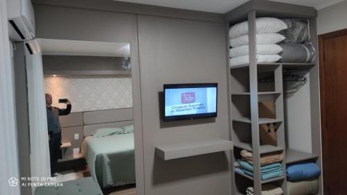 a man taking a picture of a bedroom with a mirror at Lindo apartamento no centro de Canela in Canela