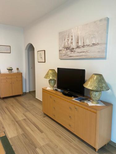 salon z telewizorem i 2 lampami na komodzie w obiekcie Vila Bilo w Primošten
