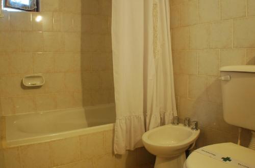 ein Badezimmer mit einem WC, einer Badewanne und einem Waschbecken in der Unterkunft Cabañas Am Hang in La Cumbrecita