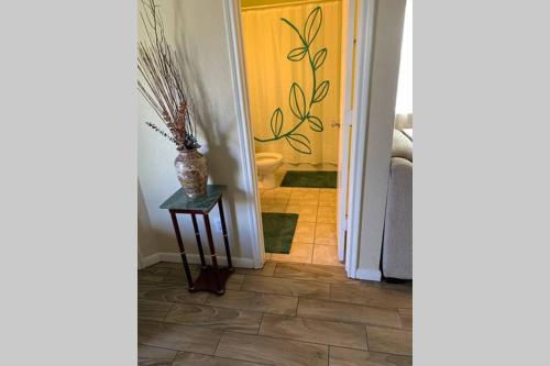 um corredor com um vaso numa mesa ao lado de uma porta em House 8122 em Humble